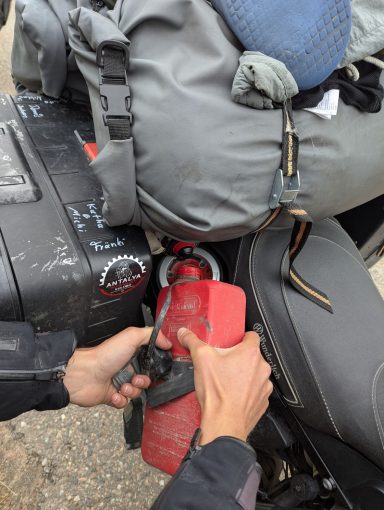 Nico befüllt mit einem extra Kanister das Motorrad