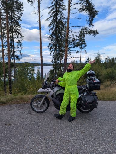 Steffi vor ihrem Motorrad mit ihrer Neongelben Regenkombi
